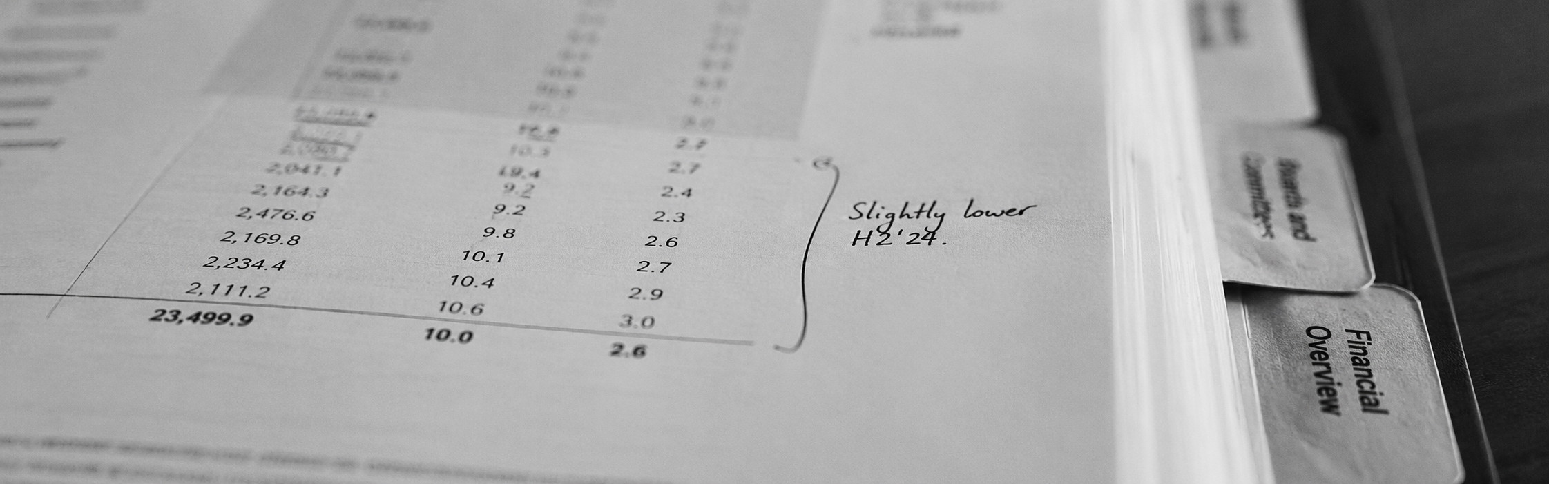 Close-up of an open board pack with financial figures and variance annotations